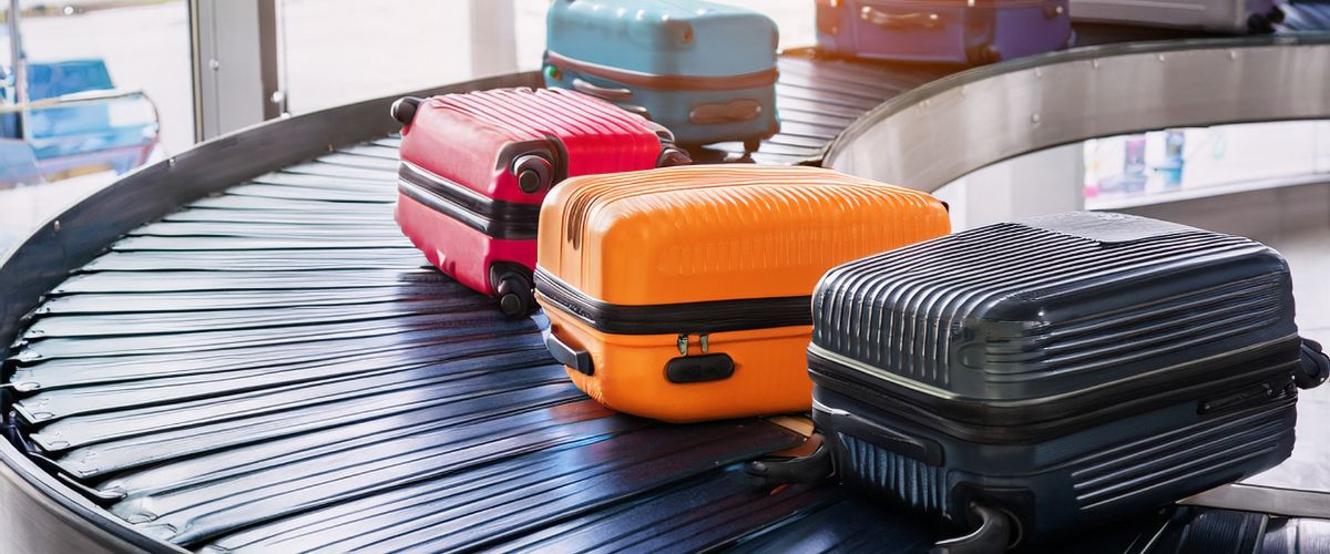 Viajero esperando su maleta en la cinta de recogida de un aeropuerto internacional tras comprobar que su equipaje no ha llegado