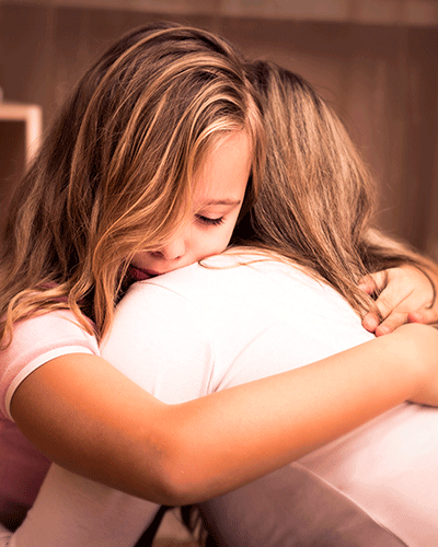 niña y mujer abrazándose 
