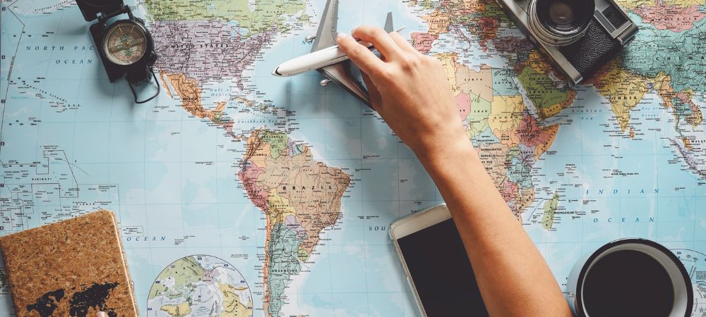 Mapa, maleta y pasaporte listos para un viaje seguro con el respaldo de Iris Global