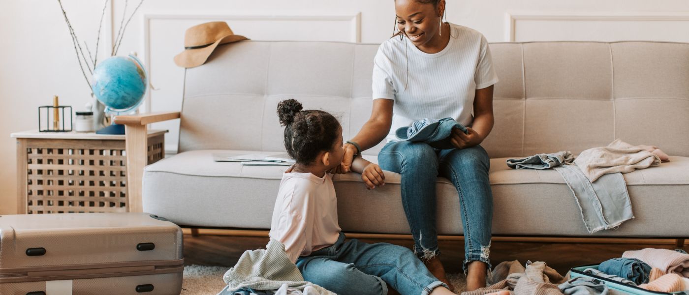 Mujer preparando su maleta junto a material deportivo, simbolizando la diferencia entre seguro de viaje y seguro de deportes con Iris Global.