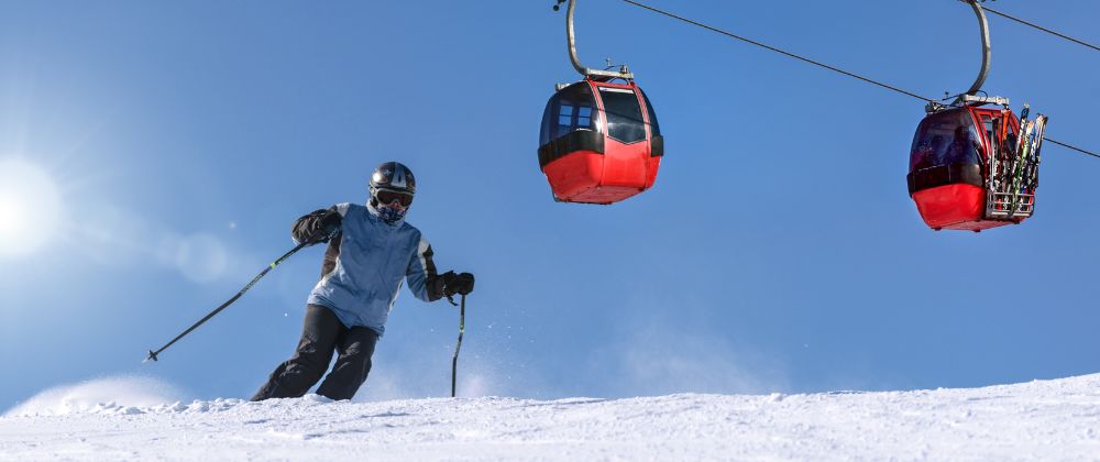 Instructor asistiendo a un esquiador accidentado en la nieve, ejemplo de asistencia incluida en el seguro deportivo de Iris Global.