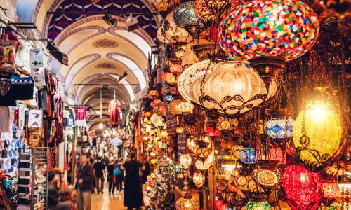 Interior del Gran Bazar de Estambul lleno de turistas y puestos de colores