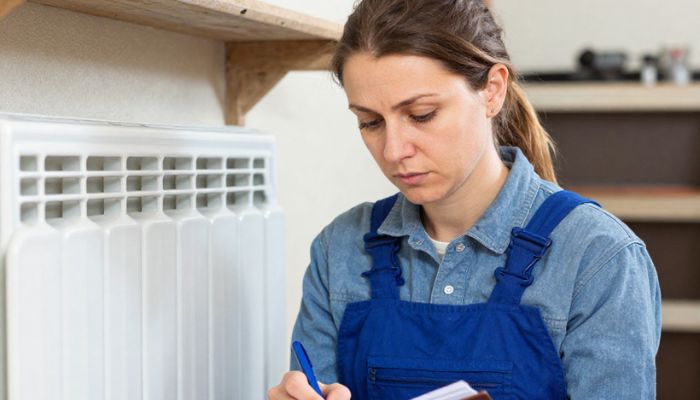 Técnico diagnosticando una avería en un sistema de climatización dentro de una vivienda
