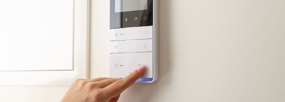 Técnico instalando y revisando una unidad de climatización junto a un equipo exterior en una vivienda