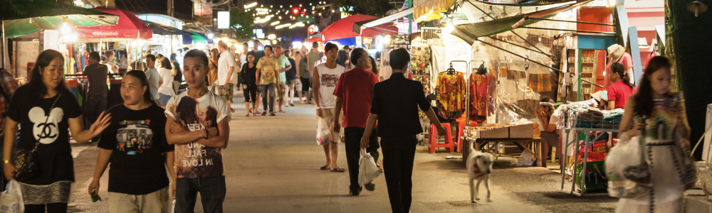 Viajera sola recorriendo con tranquilidad una calle turística de Tailandia